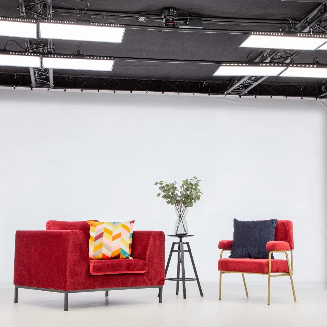 Poltronas vermelhas modernas e mesa lateral em estúdio fotográfico profissional