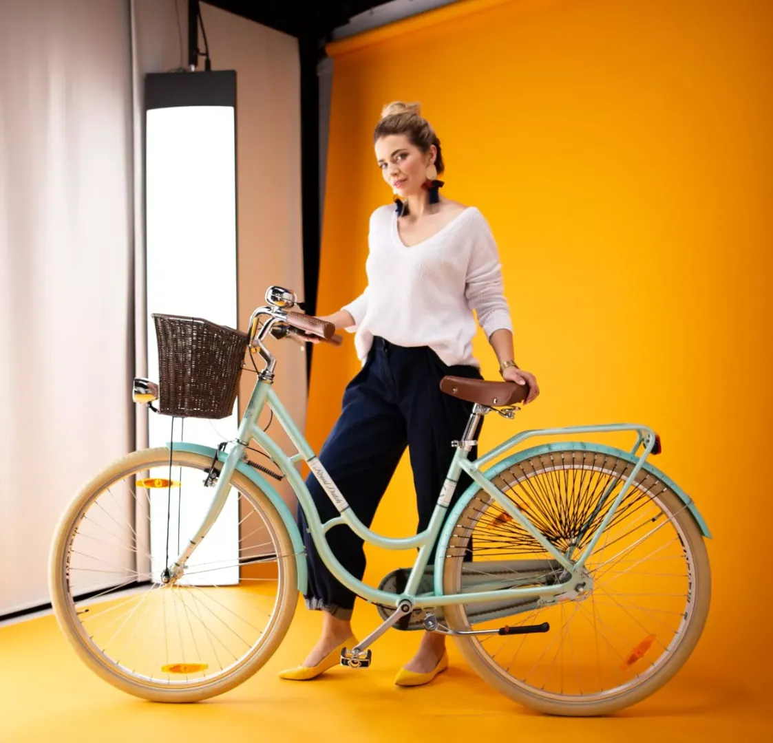 Modelo em pé ao lado de uma bicicleta no estúdio de fotografia com modelo ao vivo da Orbitvu