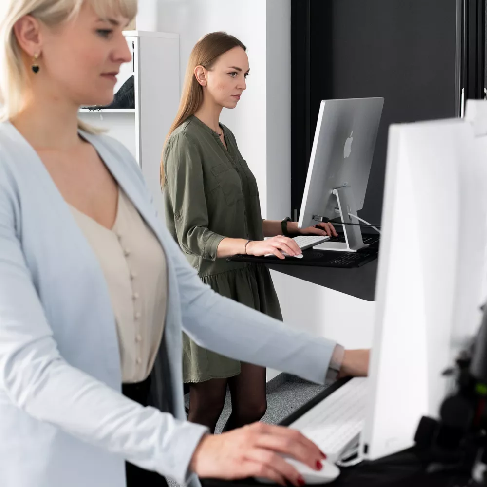 Duas mulheres trabalhando em computadores em um estúdio de fotografia Orbitvu