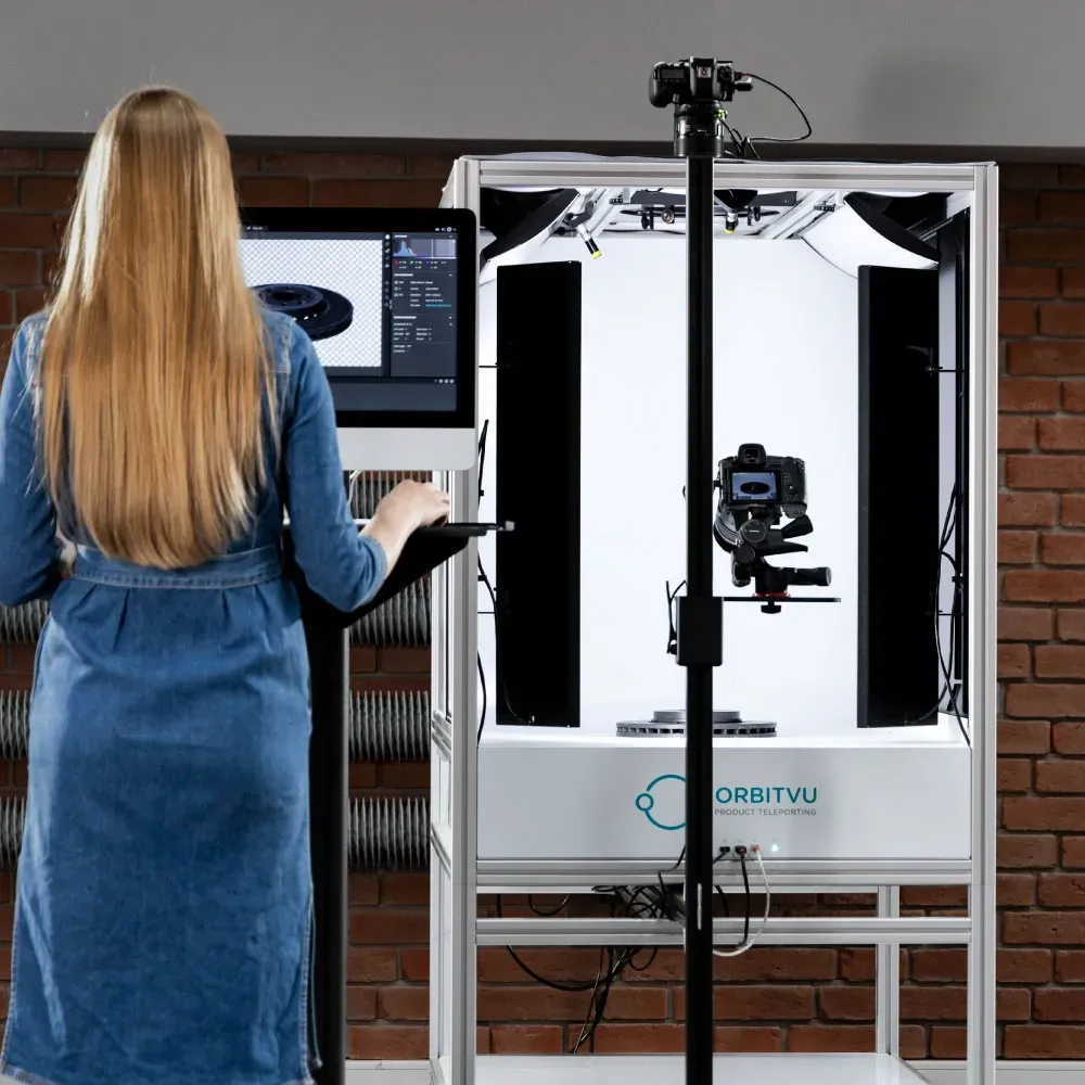 Mulher operando a montagem de estúdio fotográfico da Orbitvu