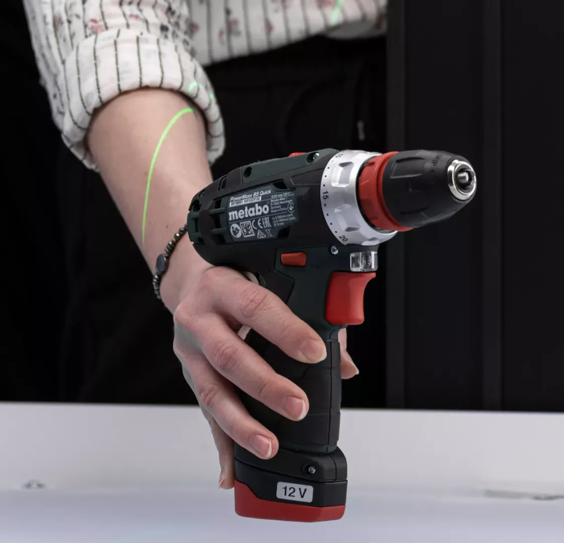 Close-up de furadeira Metabo segurada com a mão
