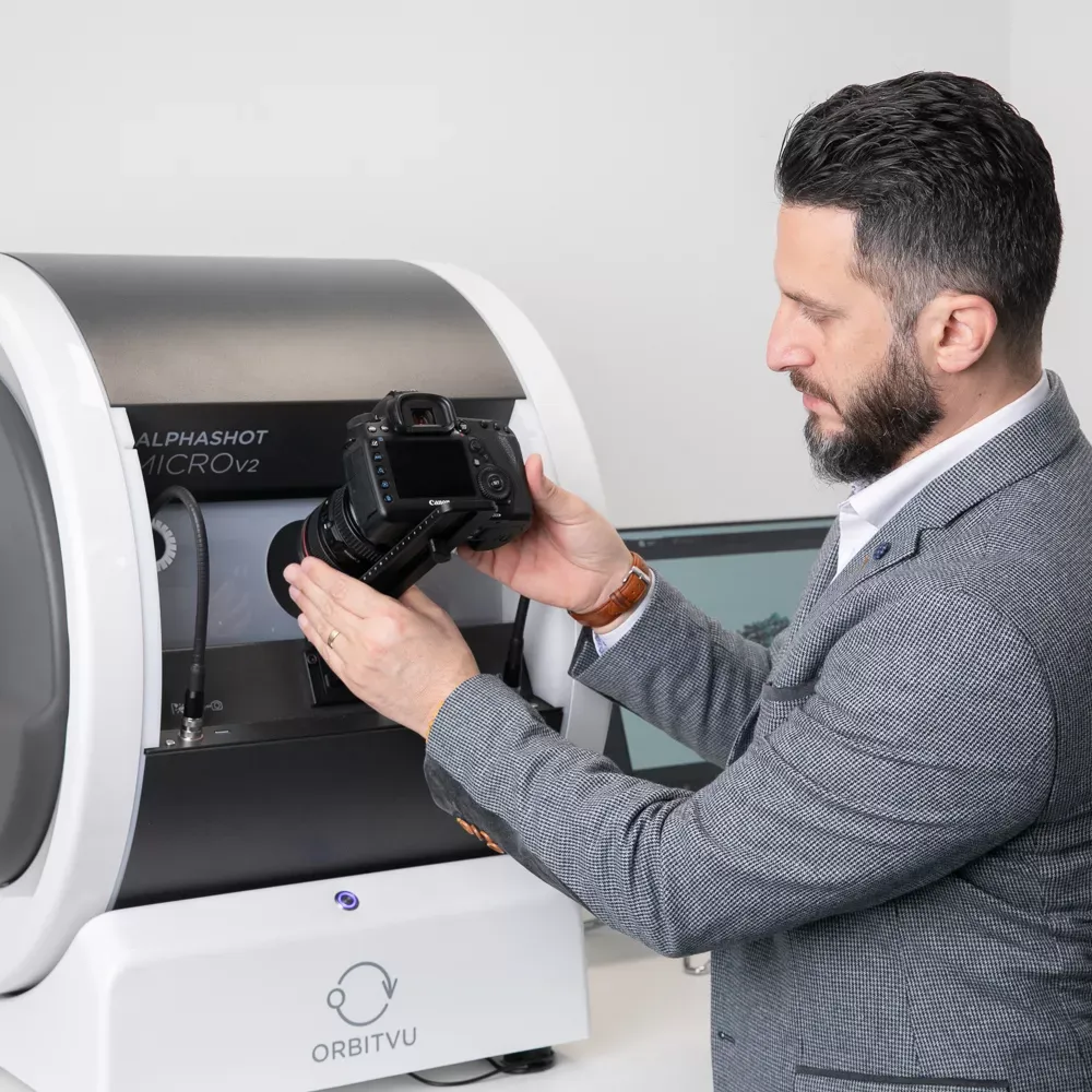 Homem conectando câmera ao Orbitvu Alphashot Micro V2